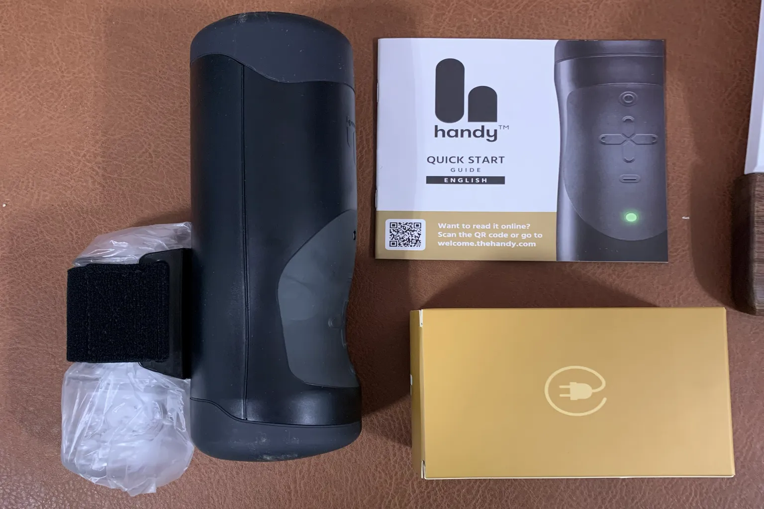 The Handy Gerät mit Zubehör, zeigt Hauptgerät, Anleitung und Verpackungsteile
