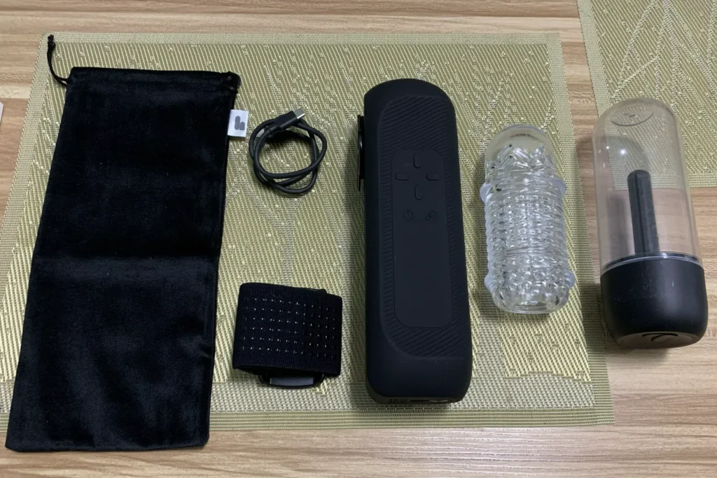 Inhalt der The Handy 2 Pro Verpackung mit Hauptgerät, TrueGrip Cup, Trocknungsbehälter, USB-C-Kabel, Befestigungsband und Aufbewahrungsbeutel.