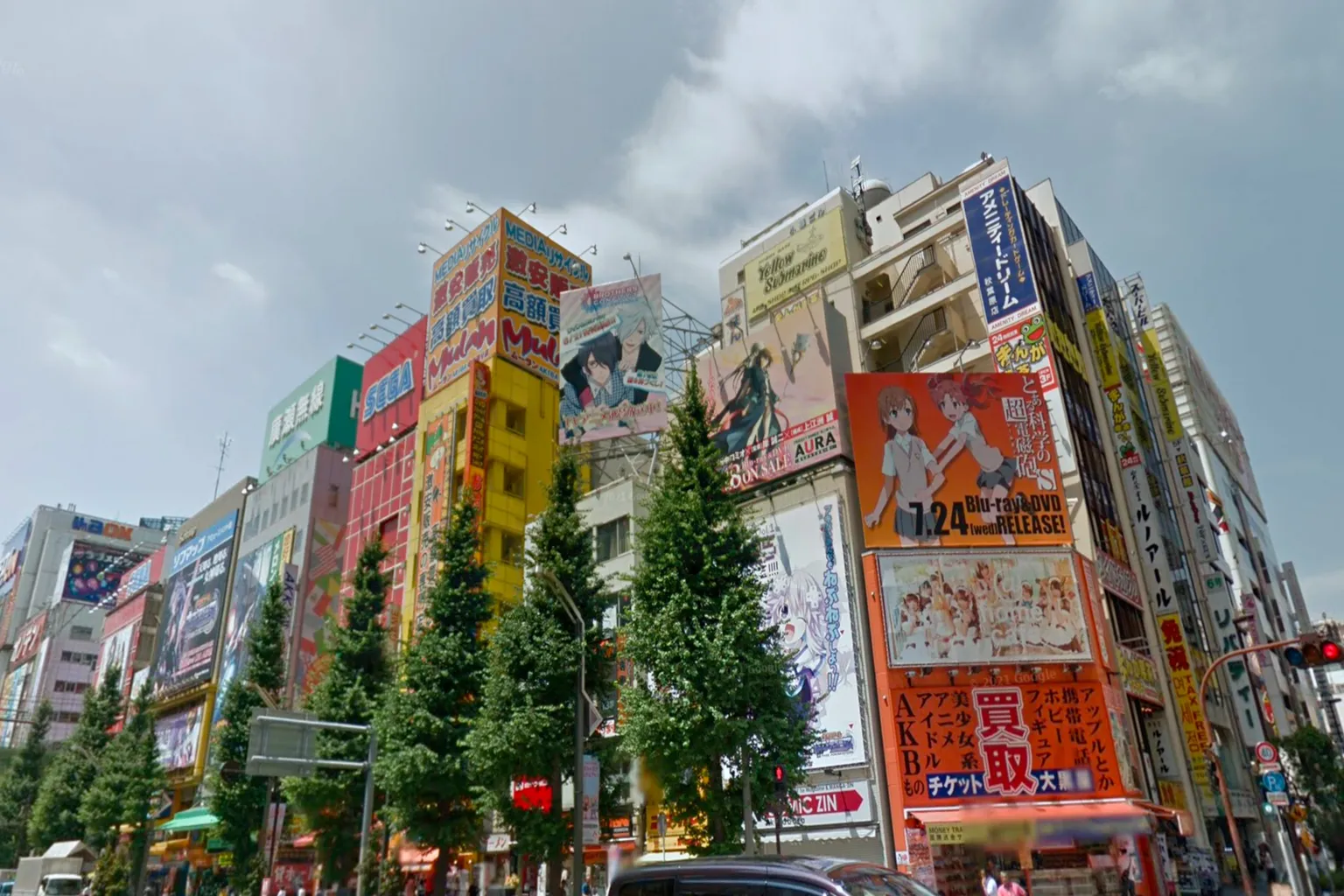 Street View of Akihabara in 2013, featuring SEGA and anime advertisement signs, with pedestrians and cars capturing the atmosphere of the electric town at that time.