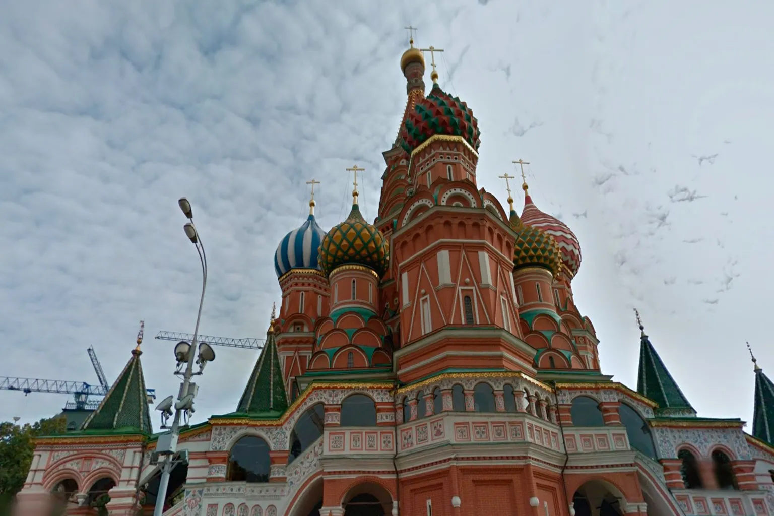 Saint Basil’s Cathedral in Moscow, Russia, with red brick walls and colorful onion-shaped domes standing out beneath an overcast sky, a defining landmark of Red Square.