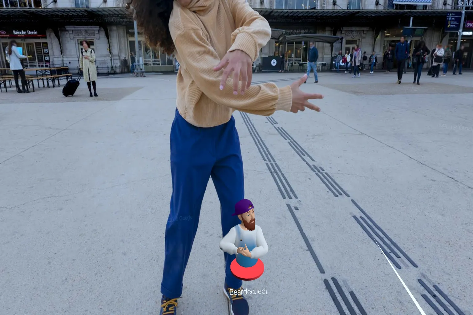 Player standing within a real-world street scene while interacting with a distant friend, with a small avatar appearing nearby and waving in a VR pose.