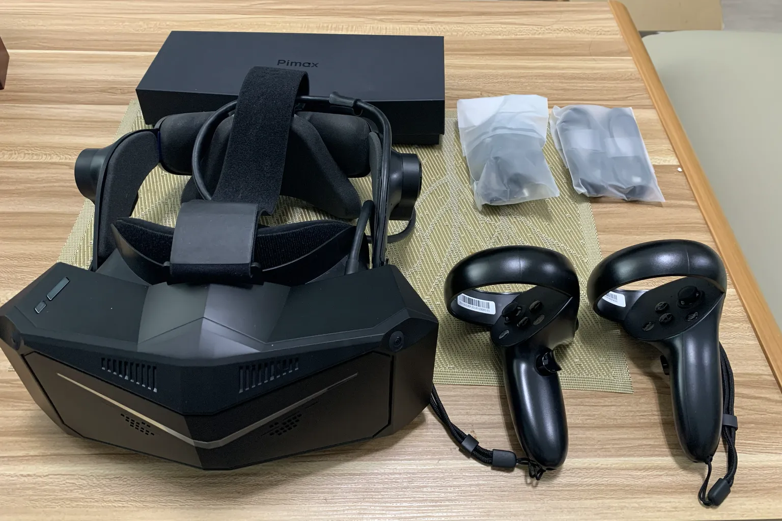 Pimax VR headset unboxed with controllers and accessories placed beside the headset.