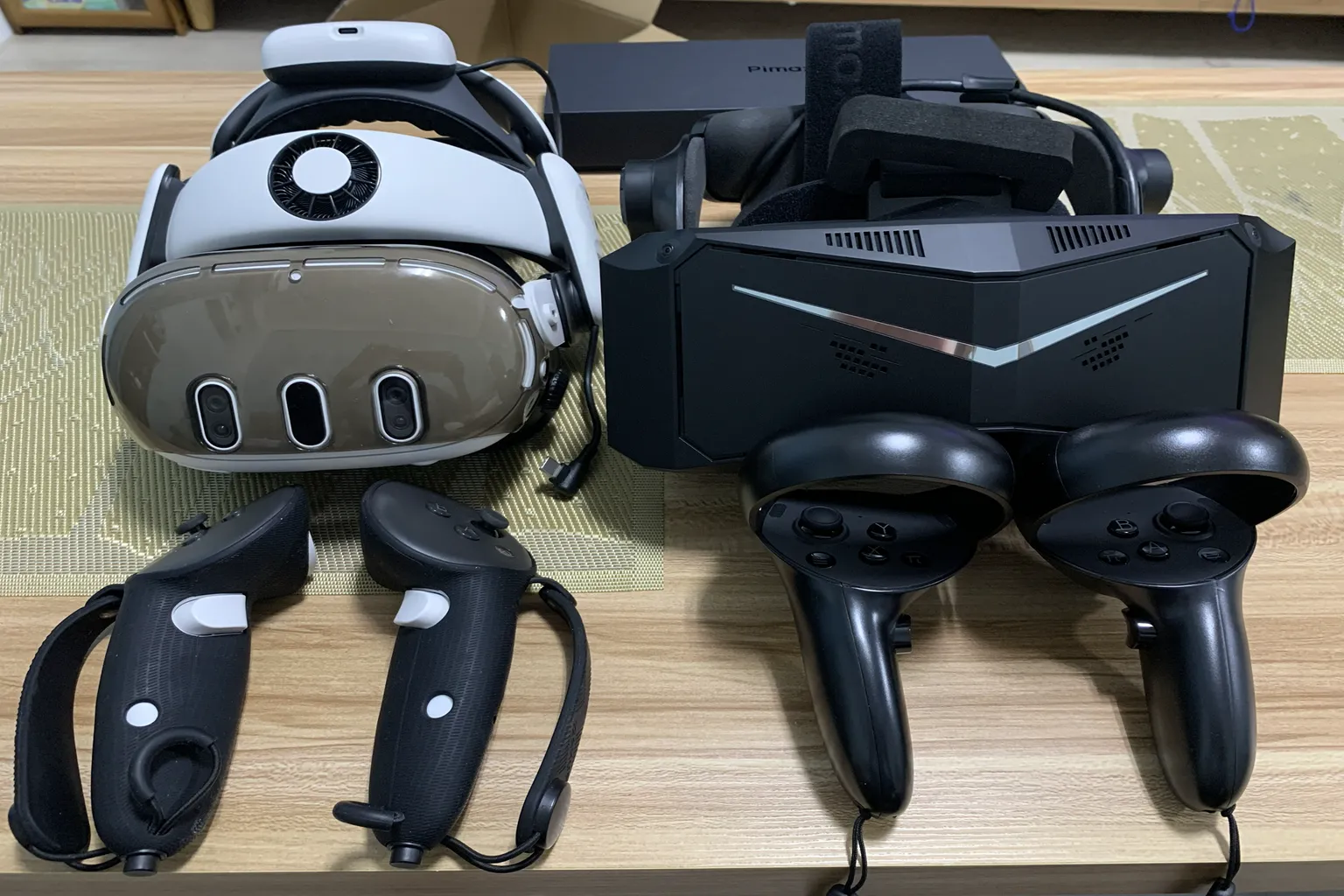 Pimax VR headset placed next to Meta Quest 3, showing the difference in headset size, controllers, and overall design.