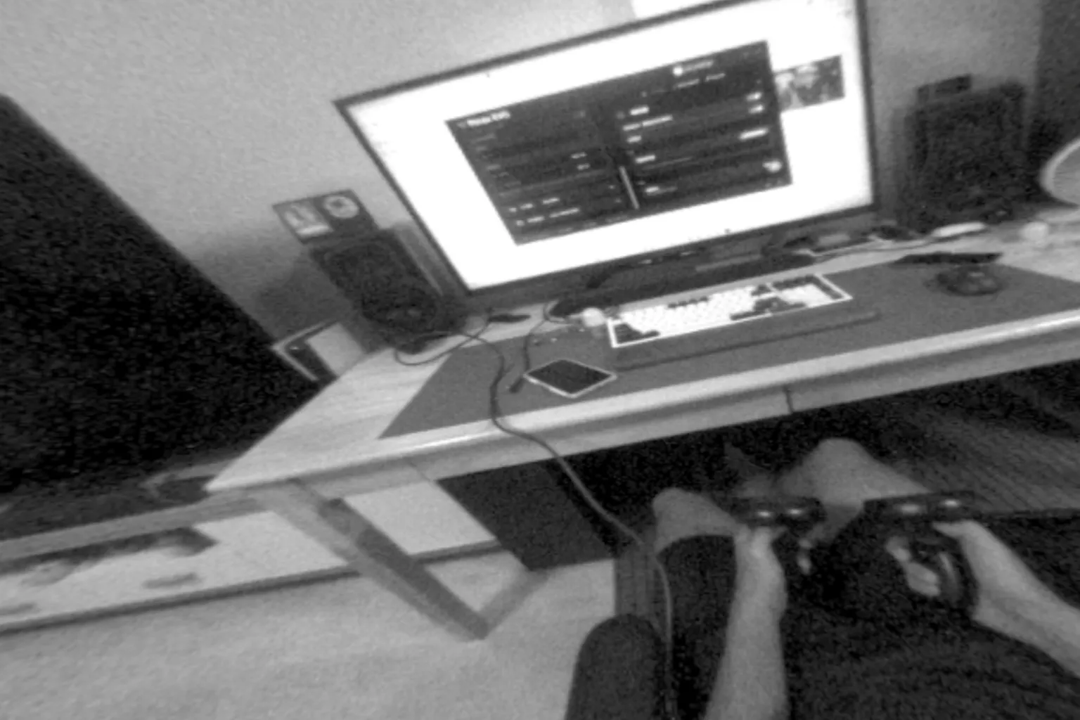 Black-and-white passthrough view from Pimax Crystal Light, showing a blurry real-world desk and monitor through the headset cameras.