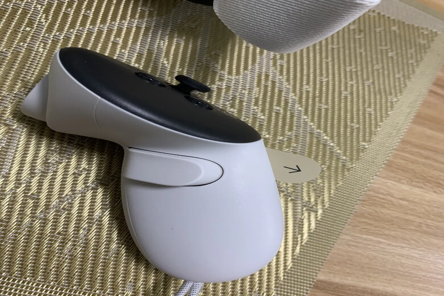コントローラーに貼られた保護シールをはがし、Meta Quest 3 の左手用コントローラーを起動する準備をする。