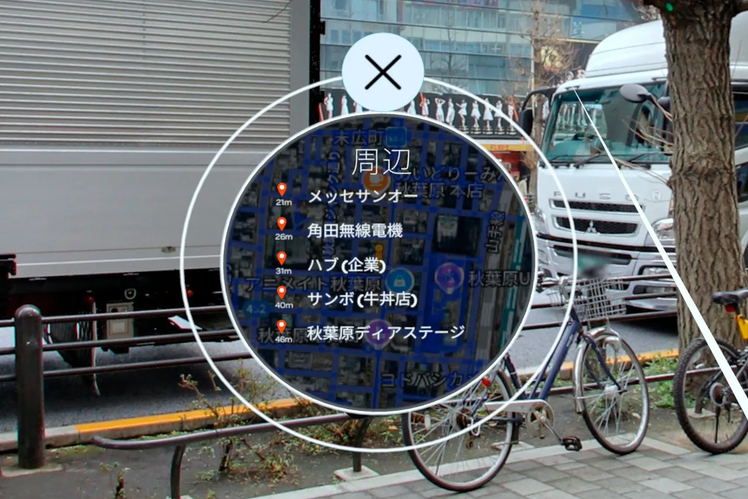 東京・秋葉原周辺のスポット一覧。無線会館や駅などが表示され、背景には実際の街並みが映っている。