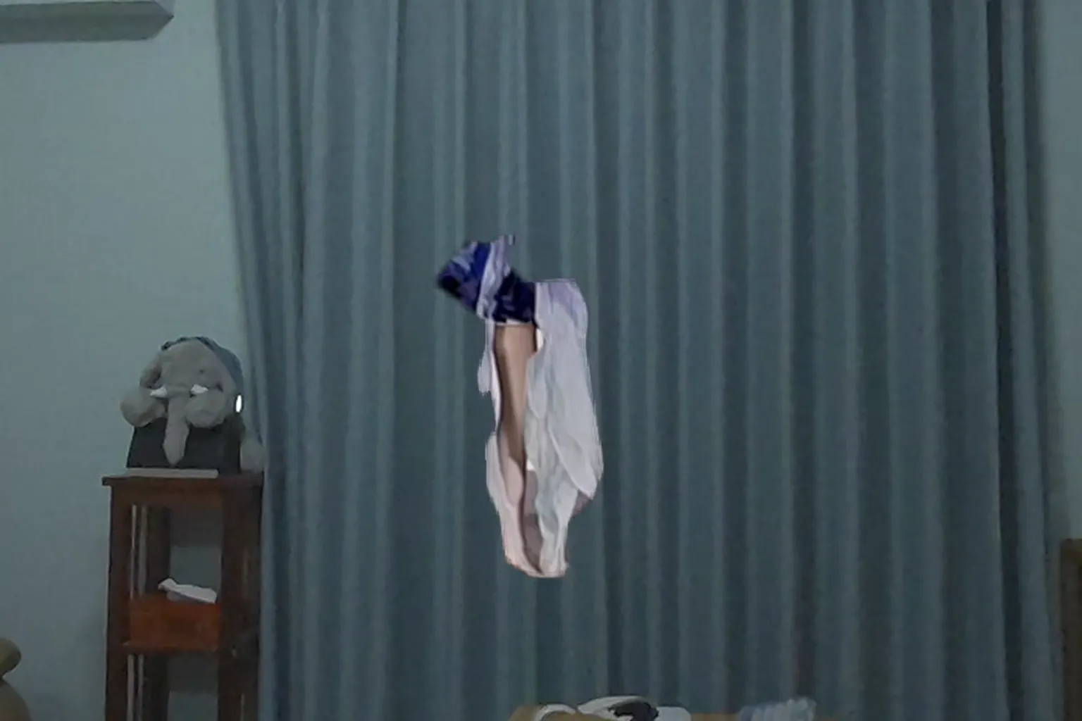 複雜背景搭配 AI 去背失敗,只呈現殘缺服裝與肢體部位,背景為居家窗簾