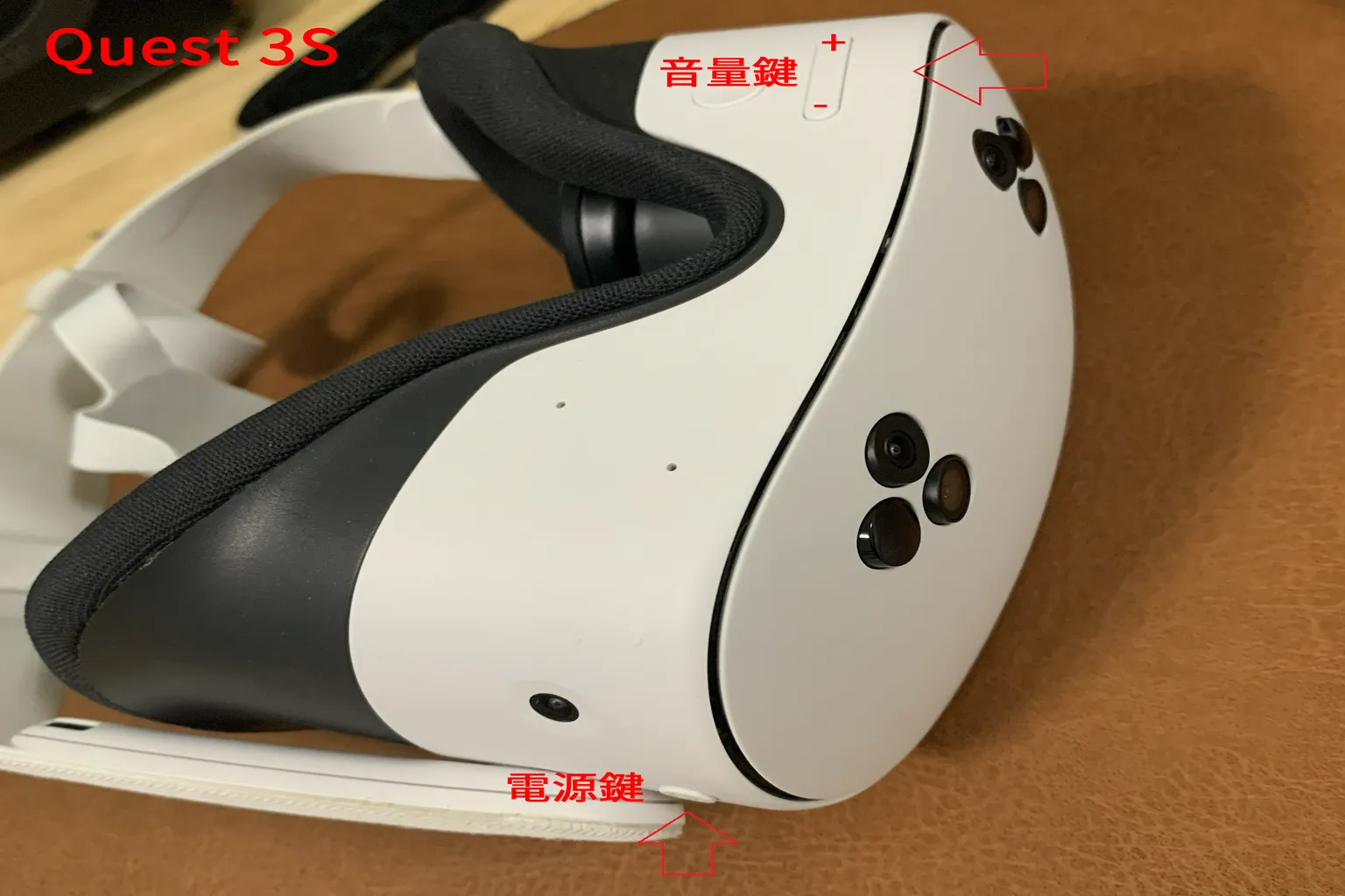 Meta Quest 3S 正面朝下放置時的按鍵位置,紅色箭頭標示電源與音量鍵位置。