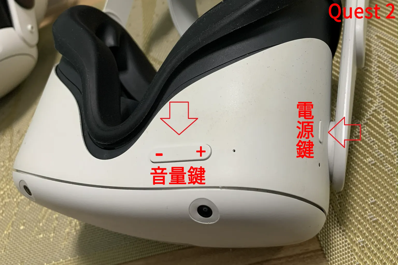 Meta Quest 2 前方按鍵位置示意,紅色箭頭指出電源與音量鍵位置,用於進入硬體重置模式。