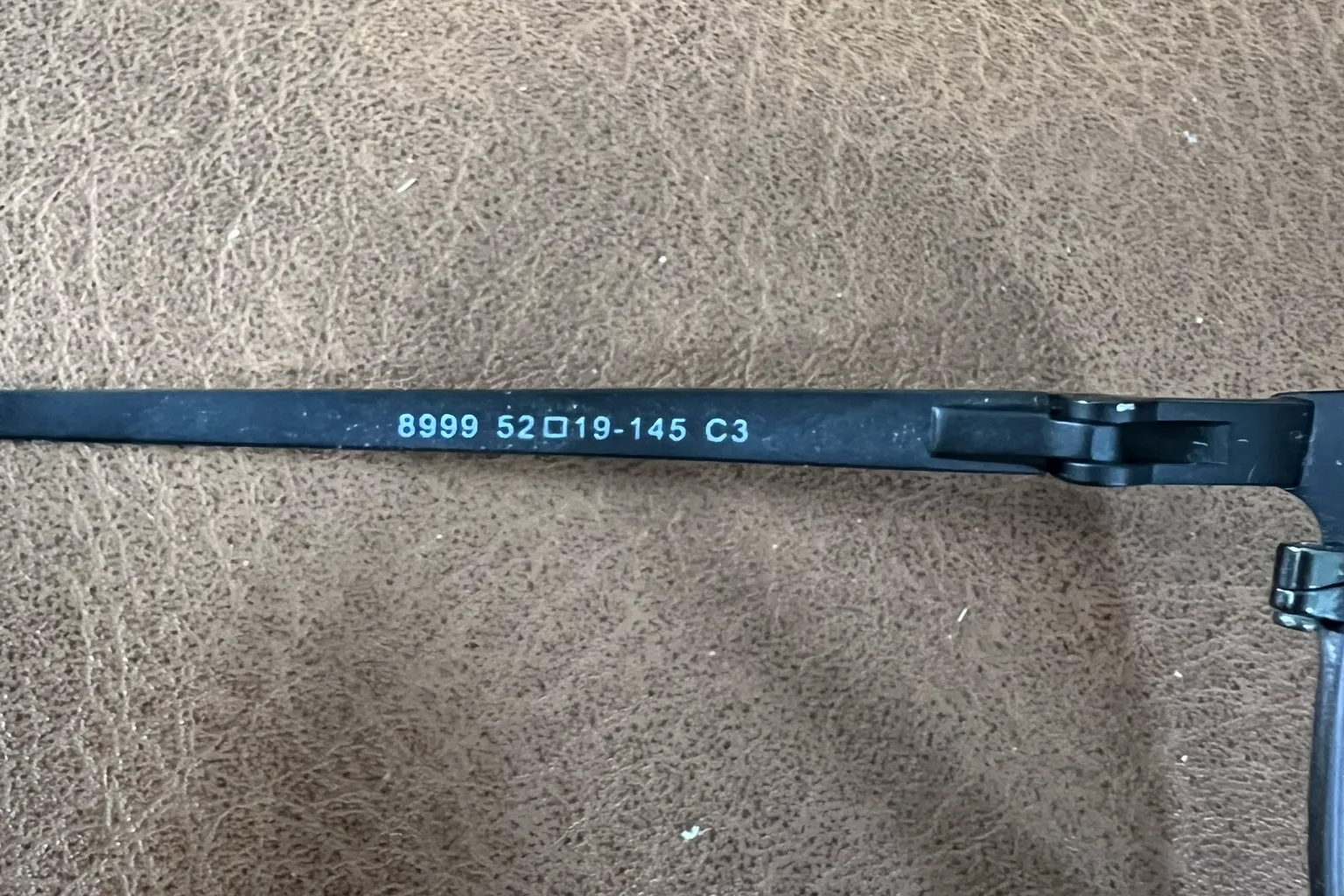 Ray-Ban 眼鏡鏡腳內側的尺寸標示,顯示 52□19-145 規格,分別代表鏡片寬度 52mm、鼻樑寬度 19mm,以及鏡腳長度 145mm。